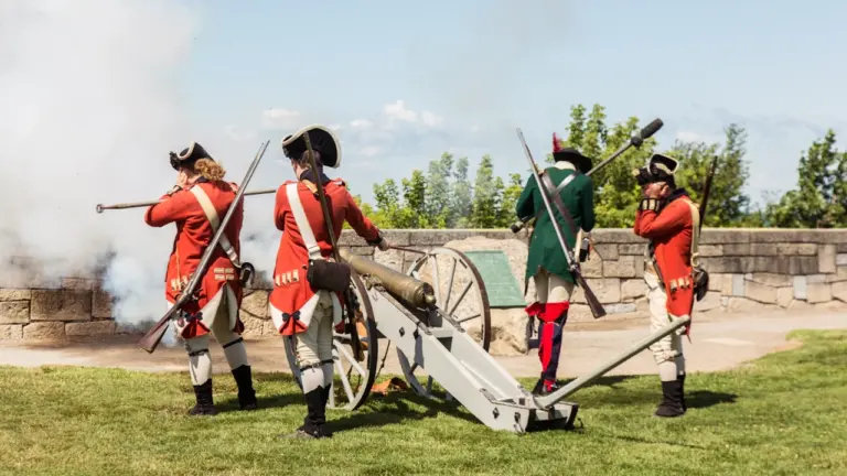 Historische Reenactment-Darsteller feuern eine alte Kanone während einer militärischen Vorführung ab.