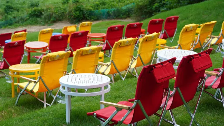 Bunte Stühle auf einer grünen Wiese für eine Open-Air-Kinoveranstaltung unter freiem Himmel