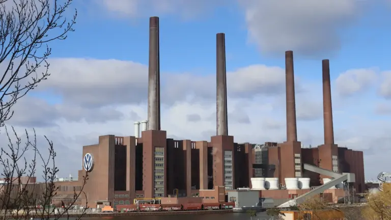Ein großes deutsches Industriewerk mit markanten Schornsteinen unter blauem Himmel.