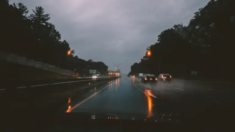 Autos fahren auf einer nassen Autobahn bei starkem Regen und schlechter Sicht.