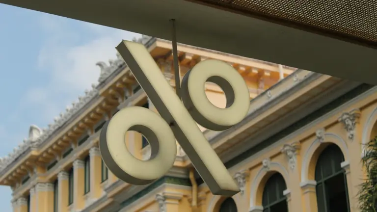 Ein großes Prozentzeichen hängt an einem historischen Gebäude, symbolisch für die aktuelle Zinspolitik.