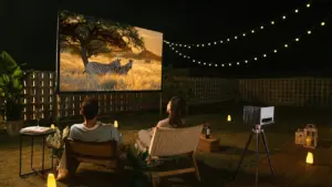 Paar genießt abends einen Film bei sommerlicher Open-Air-Kino-Atmosphäre im Garten.