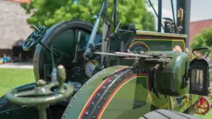 Antiker Dampftraktor auf einer Freifläche vor einem historischen Gebäude in Deutschland.