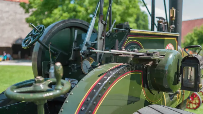 Antiker Dampftraktor auf einer Freifläche vor einem historischen Gebäude in Deutschland.