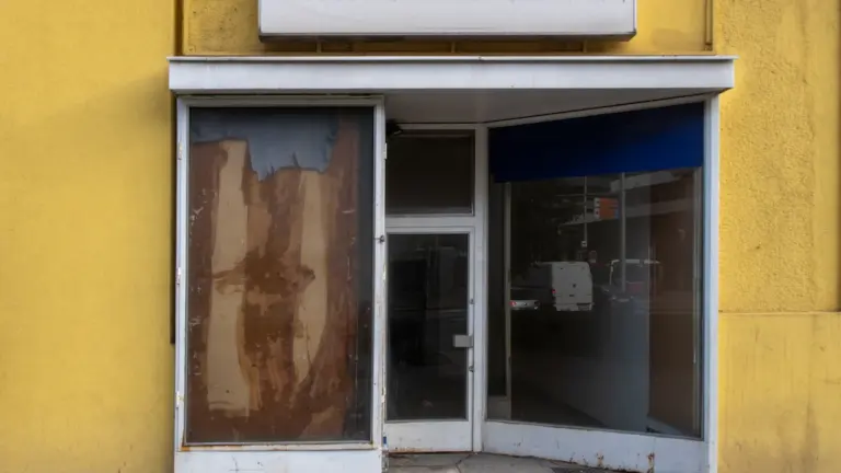 Ein Ladenlokal in Deutschland an einem Feiertag mit geschlossener Eingangstür und gelber Fassade.