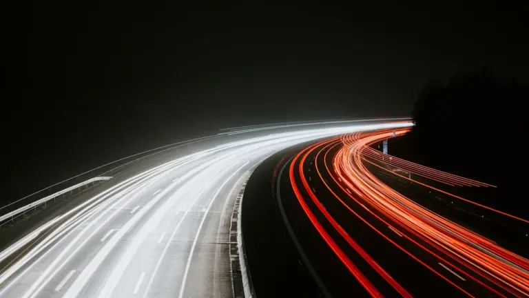 Langzeitbelichtung einer deutschen Autobahn mit Lichtspuren bei Nacht.