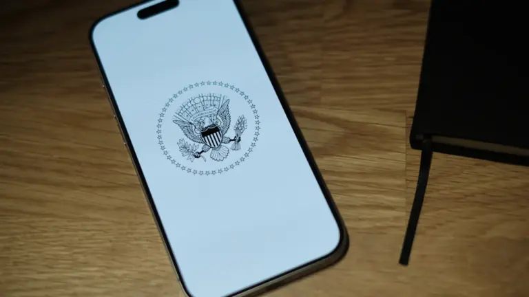 Ein weißes Smartphone liegt auf einem Holztisch, symbolisch für moderne digitale Behördengänge.