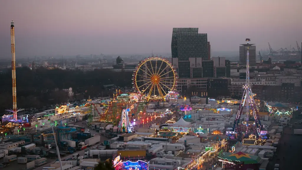 Weitläufiger Blick über den beleuchteten Hamburger Dom zur Zeit der Abenddämmerung.