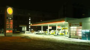 Eine nächtliche Tankstelle mit Preisanzeige bei Schnee im Winter in Deutschland.