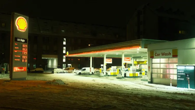 Eine nächtliche Tankstelle mit Preisanzeige bei Schnee im Winter in Deutschland.