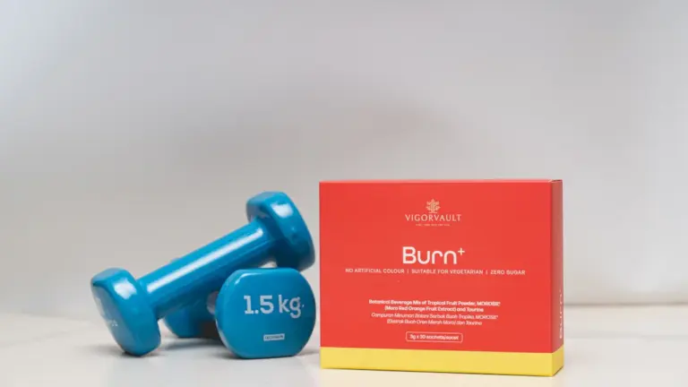 Blaue Hanteln und eine rote Supplement-Schachtel auf einem weißen Hintergrund.