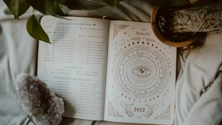 Offenes Buch mit astrologischen Symbolen und Kristallen in sanftem, natürlichem Licht.