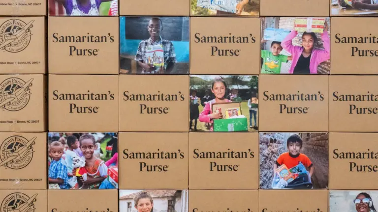 Eine Wand aus Paketen mit Fotos, die humanitäre Hilfe und internationale Verbundenheit symbolisieren.