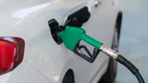 Eine Zapfpistole wird zum Tanken in ein weißes Auto eingeführt