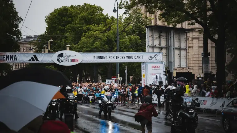 Start eines Marathons bei bewölktem Himmel in einer städtischen Umgebung.