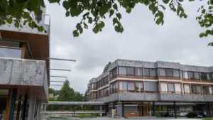 Das moderne Gebäude des Bundesverfassungsgerichts in Karlsruhe unter einem bewölkten Himmel.