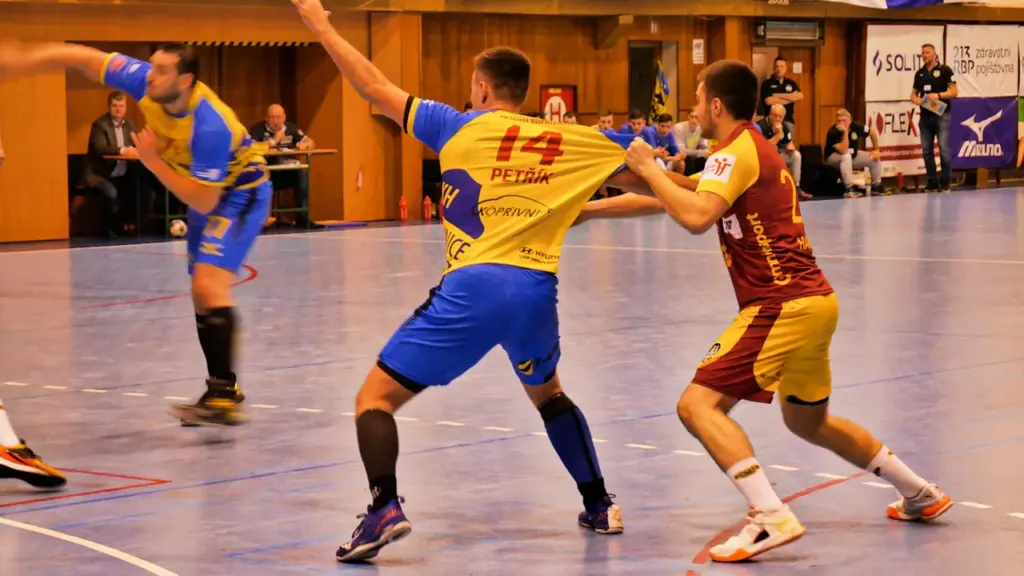 Handballspieler kämpfen während eines intensiven Spiels um den Ballbesitz auf dem Spielfeld.