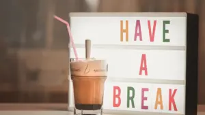 Ein Getränk steht neben einer Leuchttafel mit der Aufschrift Have a break.