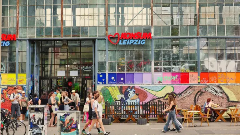 Menschen vor einem bunten Gebäude mit Leipzig-Schriftzug in der Karl-Heine-Straße.
