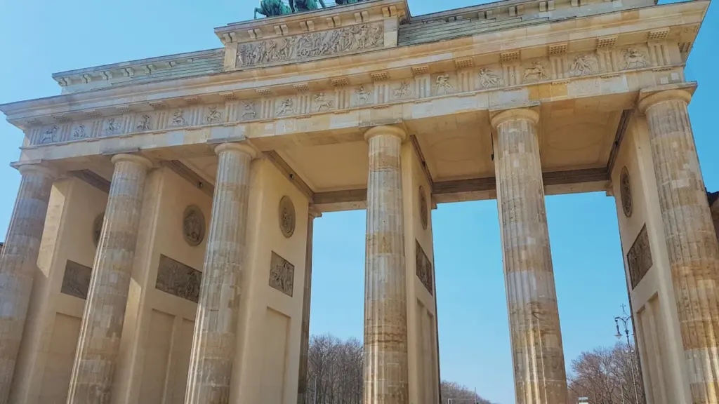 Das Brandenburger Tor in Berlin unter blauem Himmel an einem sonnigen Tag.